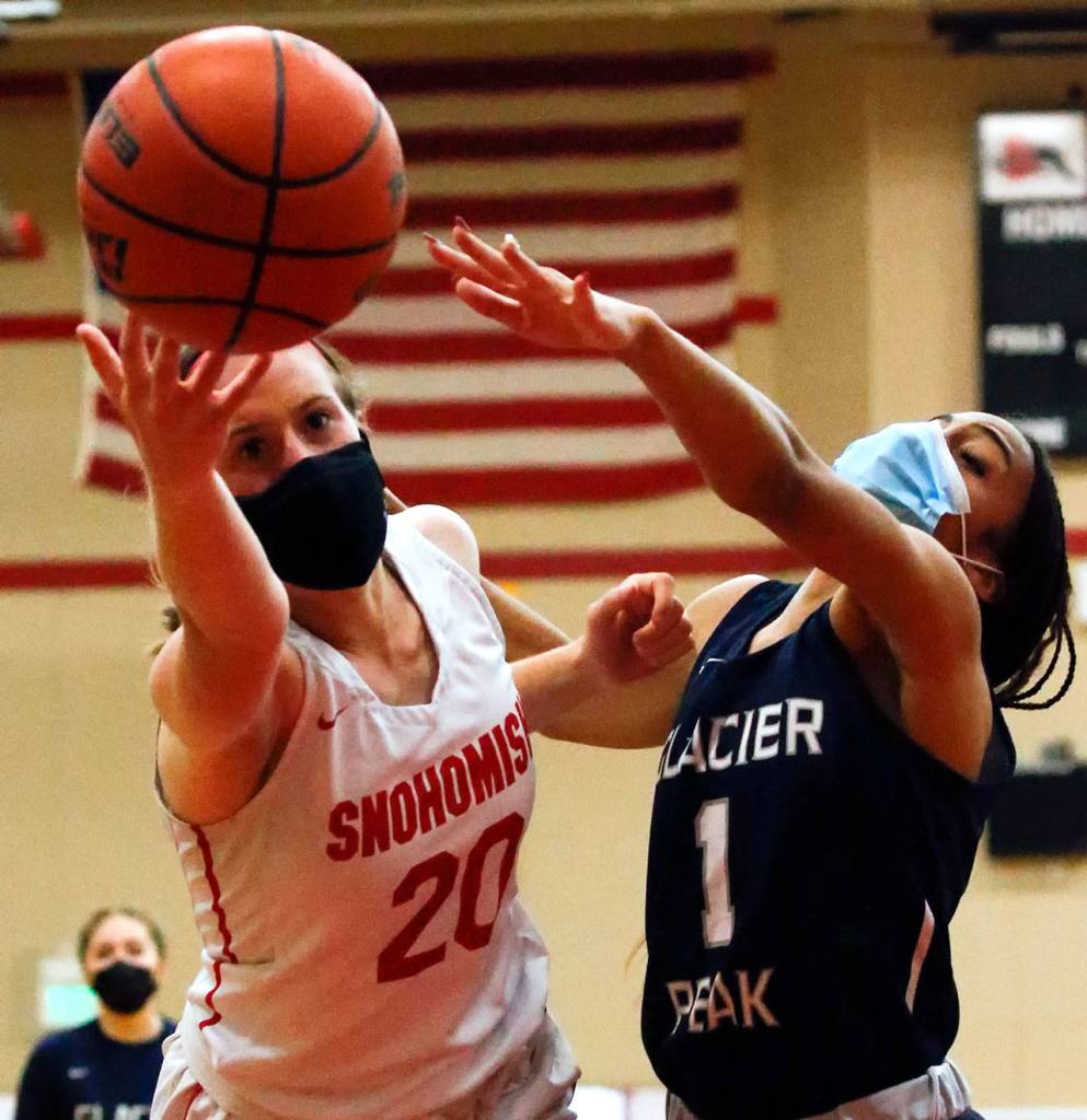 Snohomishs Sara Rodgers reaches for a loose ball with Glacier Peaks Aaliyah Collins during a game on Friday evening at Snohomish High School. Grizzlies won 59-35. (Kevin Clark / The Herald)