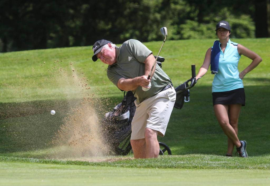 Greg Whisman hits out of a bunker. (Andy Bronson / The Herald)