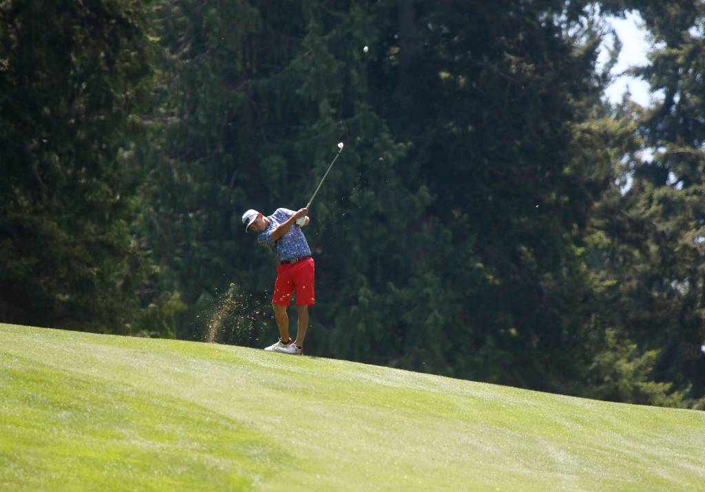 After hitting into another fairway, Mark Strickland hits a shot. (Andy Bronson / The Herald)