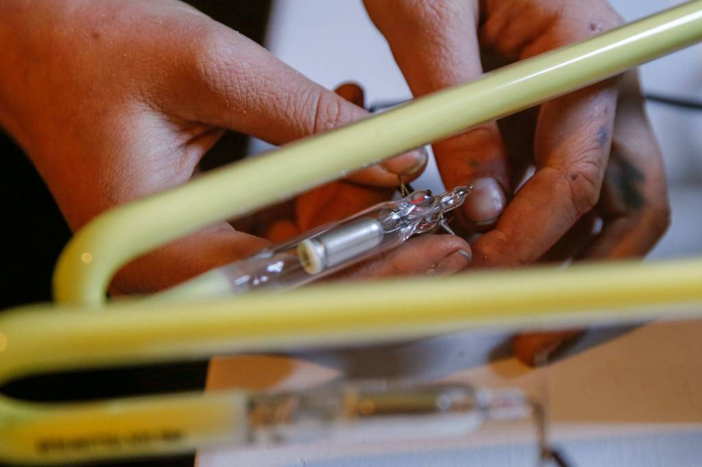 Sage Leonard assembles a neon art piece for an exhibit. She was taught by her dad, Tim Leonard. (Kevin Clark / The Herald)