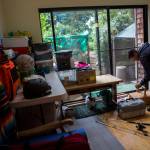 Deven Boyce adds a fishing pole and tackle box to a supply pile in preparation for his cross-country bike ride. (Olivia Vanni / The Herald)
