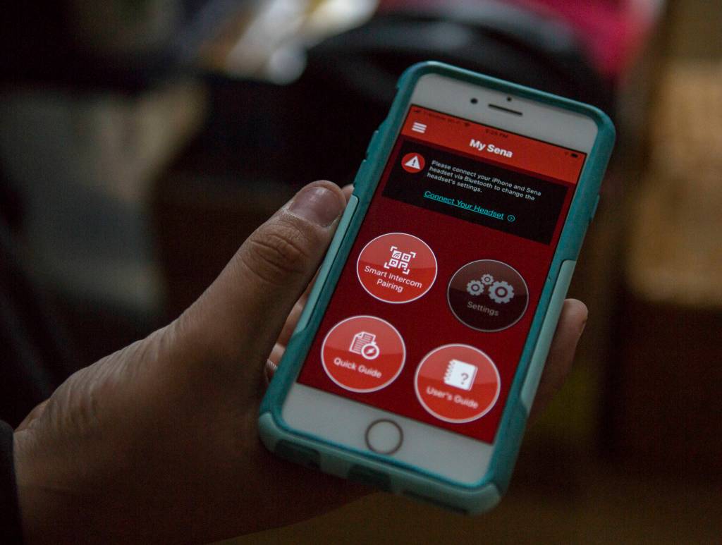Deven Boyce shows an app that will connect to a bluetooth-equipped helmet that will allow him to talk to his grandfather and to connect online. (Olivia Vanni / The Herald)