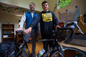 Jon Boyce, left, and his grandson Deven, 14, who will be completing 2 month long bike trip across the country, in their home surrounded by their supplies and planned route on Thursday, May 27, 2021 in Mukilteo, Wash. (Olivia Vanni / The Herald)