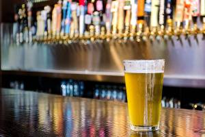 A pint of beer sitting on the bar.