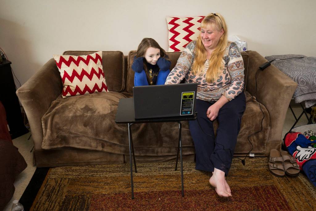 Heather Adams reads with her youngest daughter, Phoenix, at their apartment in Arlington. (Andy Bronson / The Herald)