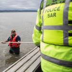Beau Jess walks on a sandbar as people get out of the boat to start their search for Charlie Cortez on May 28 in Possession Sound. (Olivia Vanni / The Herald)