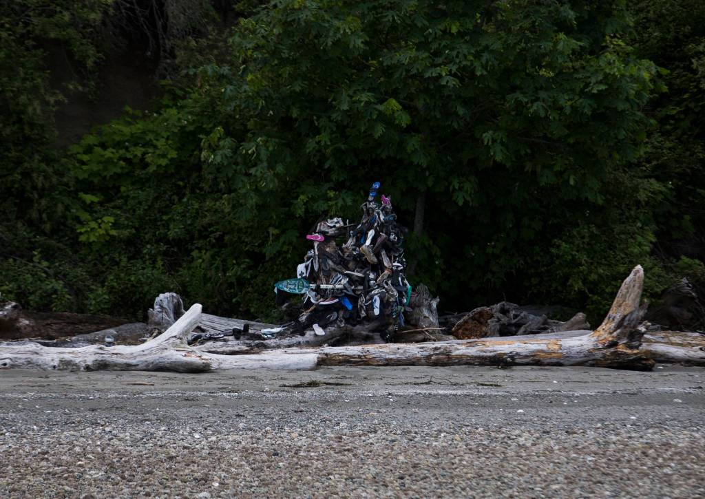 A stump on Hat Island displays items that have washed up on shore in Possession Sound. Volunteers check the stump regularly for Cortezs boots and other items. (Olivia Vanni / The Herald)