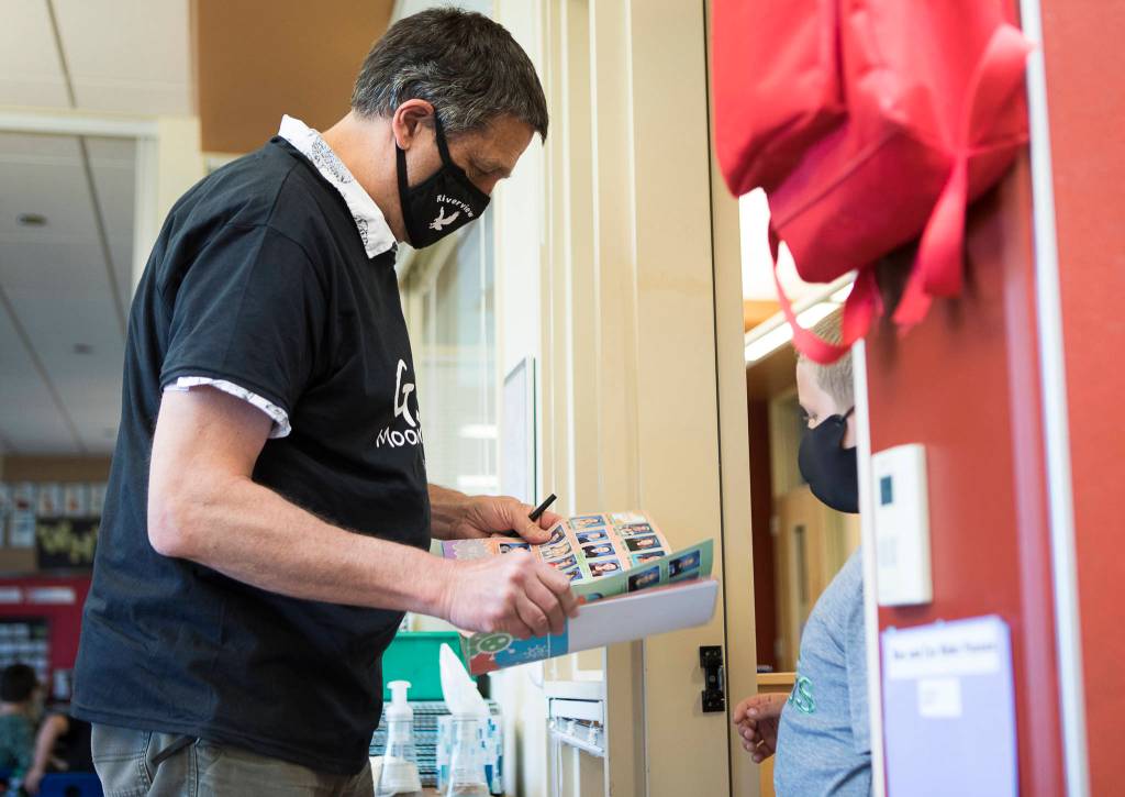Jeff Thoreson signs a student yearbook on his last in-person day of school on Thursday in Snohomish. (Olivia Vanni / The Herald)