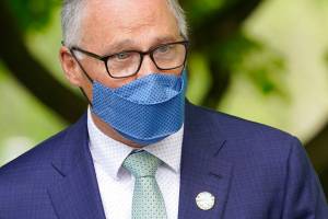 Washington Gov. Jay Inslee speaks before signing a bill into law in Tukwila, Wash., Tuesday, May 4, 2021, that levies a new capital gains tax on high profit stocks, bonds and other assets for some residents of Washington state. (AP Photo/Ted S. Warren)
