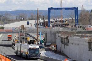 In this April 6, 2020 photo, a bus drives past a roadwork construction project in Seattle where ramps off of the Highway 520 floating bridge meet Montlake Blvd. that has been shut down due to concern over the spread of the coronavirus. The $2 trillion federal stimulus package enacted in March included billions of dollars for public transit systems, publicly owned commercial airports and Amtrak passenger train service, but earmarked nothing for state highways and bridges. Many of those projects across the country have been put on hold because of a sharp drop in fuel taxes, tolls and user fees since the coronarvirus-related shutdowns suspended much of the U.S. economy. (AP Photo/Ted S. Warren)