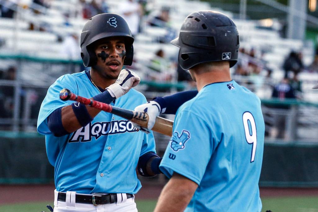 The AquaSox Miguel Perez (left) is welcomed home by teammate Zach DeLoach after hitting a home run in the bottom of the third inning during a game against the Hops on Thursday evening at Funko Field in Everett. (Kevin Clark / The Herald)