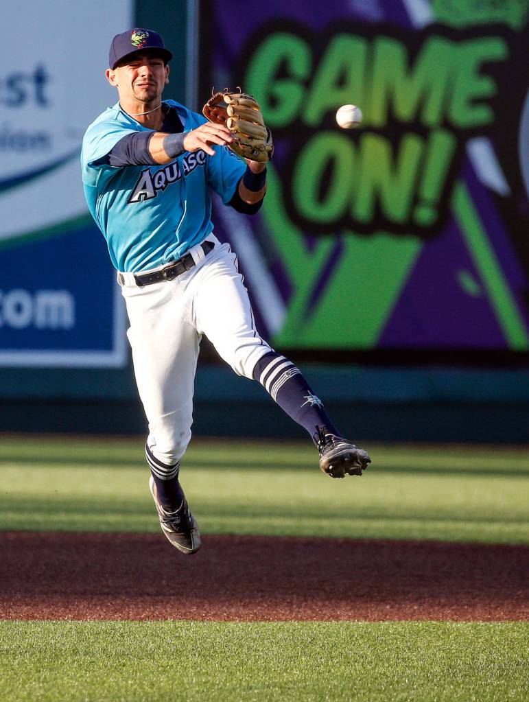The AquaSoxs Patrick Frick throws to first base during a game against the Hops on Thursday evening at Funko Field in Everett. (Kevin Clark / The Herald)