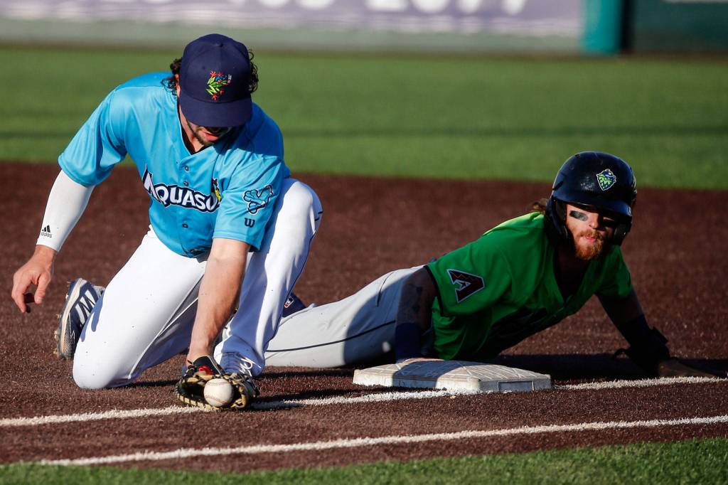 The AquaSoxs Connor Hoover attempts a tag on the Hops Cam Coursey during a game on Thursday evening at Funko Field in Everett. (Kevin Clark / The Herald)