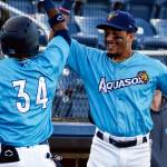 AquaSox's Miguel Perez (left) is greeted at the dug out by teammate Joseph Rosa Thursday evening at Funko Field in Everett on June 3, 2021. (Kevin Clark / The Herald)
