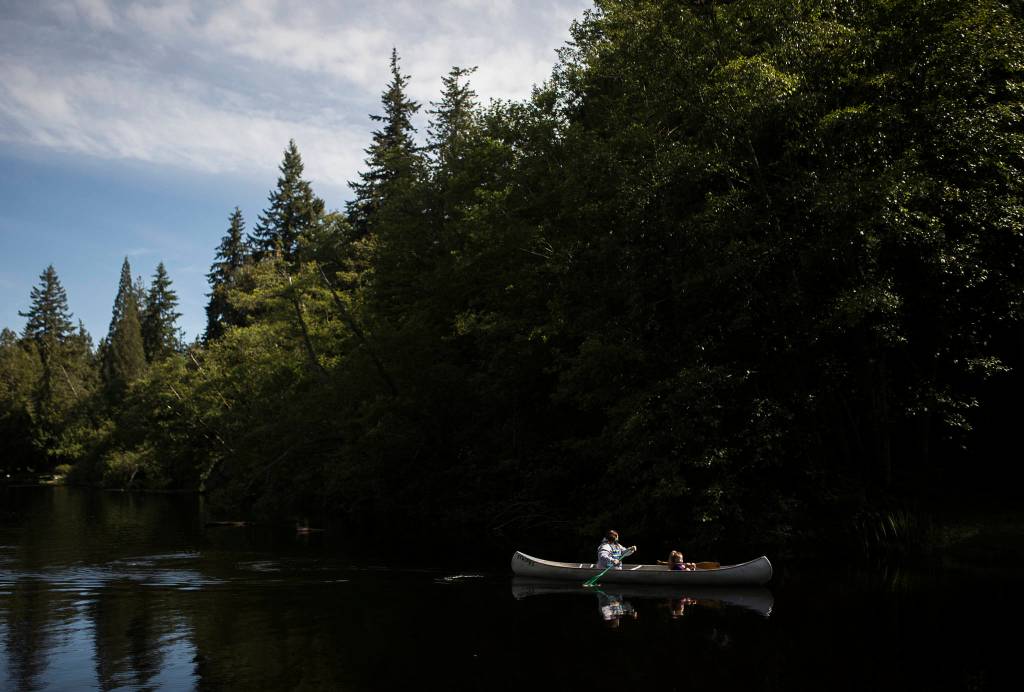 Hannah Davis and Zienna Zink paddle toward shore at Camp Killoqua. (Olivia Vanni / The Herald)