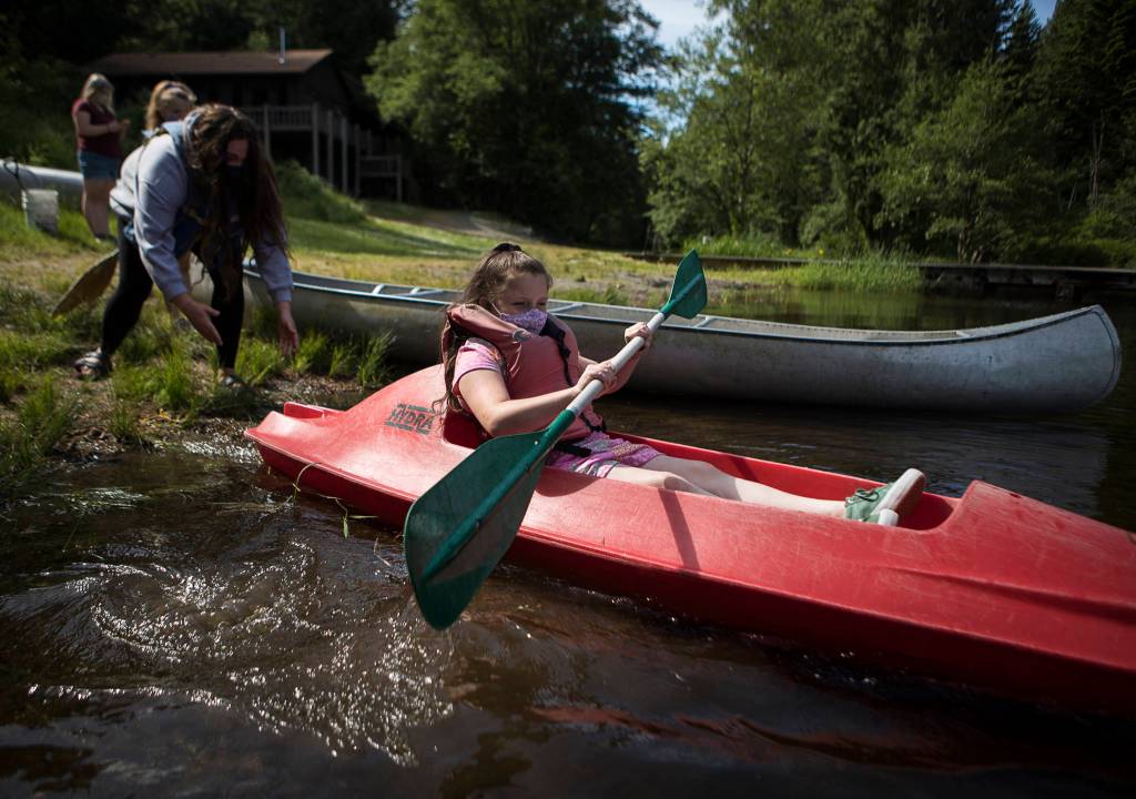 Gemma Rommel, 8, is pushed out into the water aboard a kayak. (Olivia Vanni / The Herald)