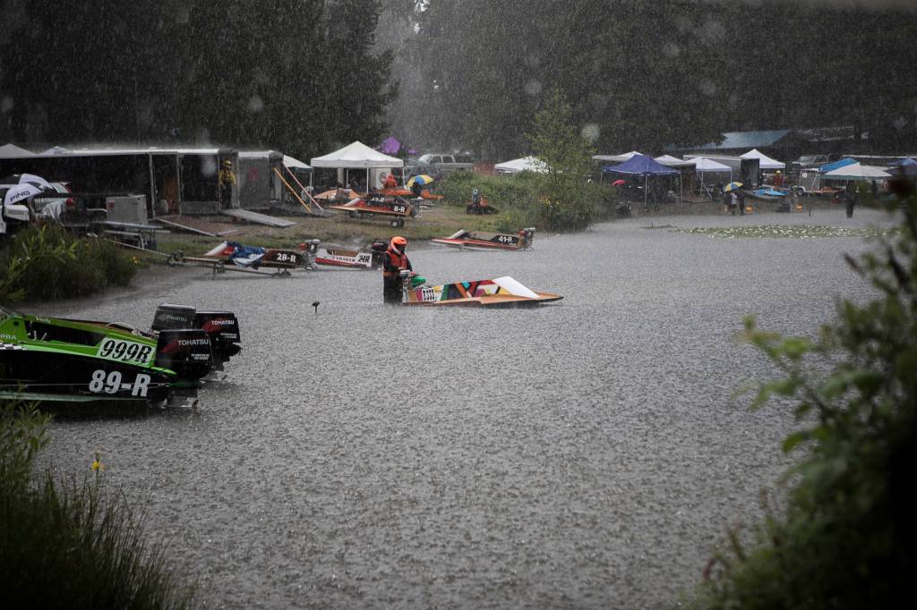 A racer holds onto his boat in the pits as a rainstorm passes through during the Silver Lake Regatta on Saturday, June 5, 2021 in Everett, Wash. (Olivia Vanni / The Herald)