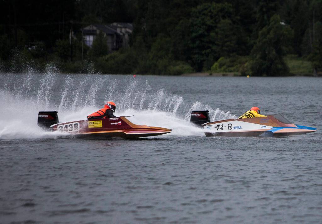 Torei McGregor, left, and Mitchell Sampson race around the first turn during the Silver Lake Regatta on Saturday, June 5, 2021 in Everett, Wash. (Olivia Vanni / The Herald)