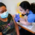 Medical assistant Andreea Marian, right, gives a COVID-19 vaccine to Gabina Morales at a clinic at PeaceHealth St. Joseph Medical Center Thursday, June 3, 2021, in Bellingham, Wash. Washington is the latest state to offer prizes to encourage people to get vaccinated against COVID-19, with Gov. Jay Inslee on Thursday announcing a series of giveaways during the month of June that includes lottery drawings totaling $2 million, college tuition assistance, airline tickets and game systems. (AP Photo/Elaine Thompson)