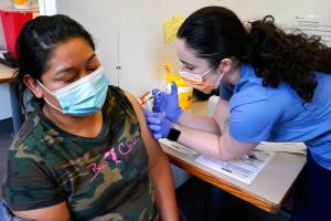 Medical assistant Andreea Marian, right, gives a COVID-19 vaccine to Gabina Morales at a clinic at PeaceHealth St. Joseph Medical Center Thursday, June 3, 2021, in Bellingham, Wash. Washington is the latest state to offer prizes to encourage people to get vaccinated against COVID-19, with Gov. Jay Inslee on Thursday announcing a series of giveaways during the month of June that includes lottery drawings totaling $2 million, college tuition assistance, airline tickets and game systems. (AP Photo/Elaine Thompson)