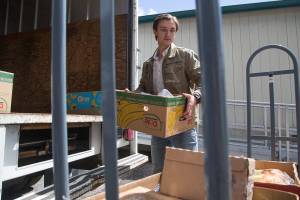 Ryan Whitton, executive director of the Granite Falls Food Bank, unloads donated foods from a truck on Wednesday, June 9, 2021 in Granite Falls, Washington. Whitton became the executive director at the age of 22 in November 2020.  (Andy Bronson / The Herald)
