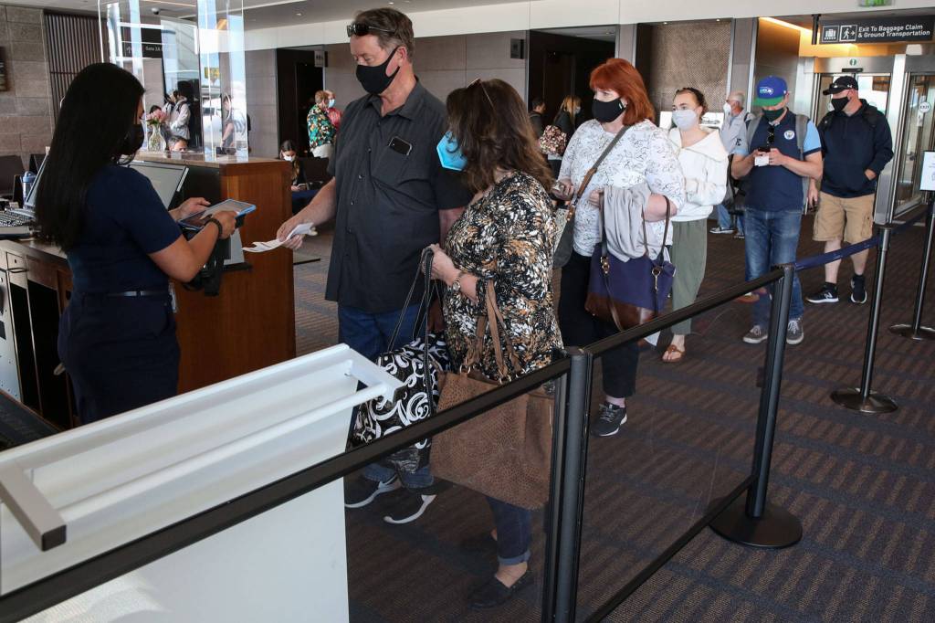 Passengers line up to board a flight to Las Vegas at Paine Field in Everett on May 19. (Kevin Clark / Herald file)