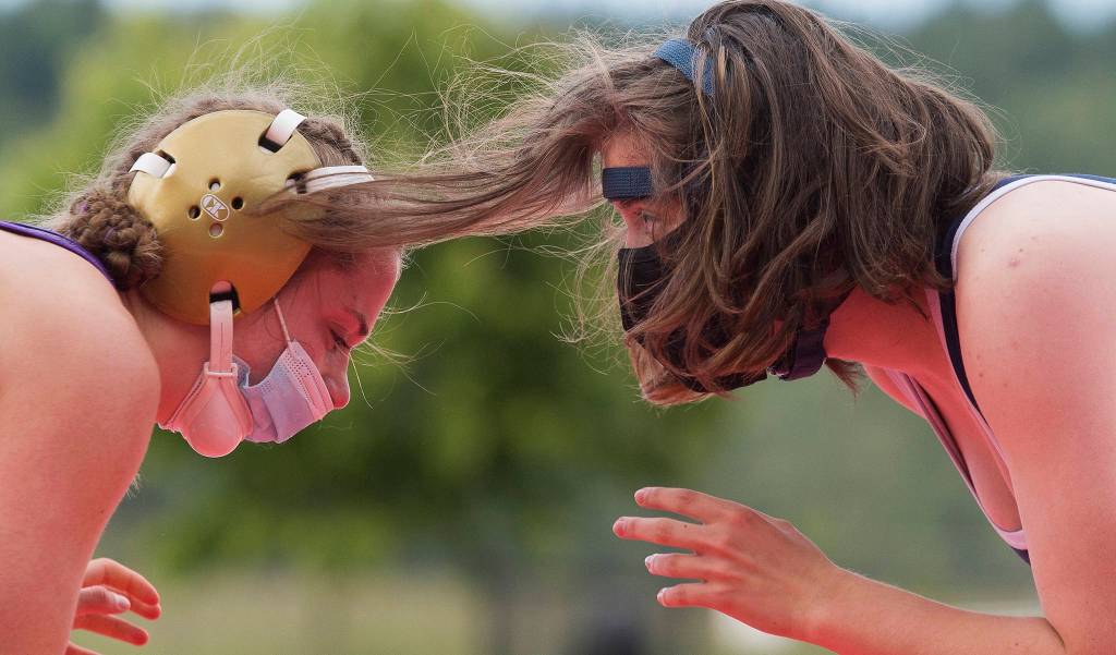 The hair of Glacier Peaks Parker LaStala seems to being reaching for her opponent, Lake Stevens Madison Bowers, during their match at a girls wrestling scramble held outside at Marysville Pilchuck High School on Tuesday in Marysville. Bowers beat LaStala in the match. (Andy Bronson / The Herald)