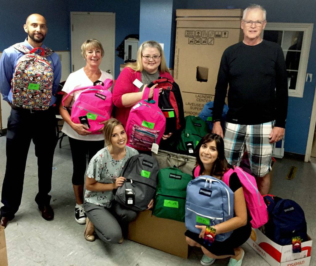 Katie Thurston, left in front row, was among volunteers from First Financial Northwest Bank and the Edmonds Young Professionals packing 135 backpacks with school supplies for the YWCA School Days program in 2018. Front row at right is Yvonne De La Rosa. Back row, from left: Yusuf Hansia, Jane Tocco, Kristie Gilchrist and Gary Walderman. (Herald file photo)