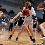 Lake Stevens Carmen Long (center) looks to pass out of Arlingtons defensive pressure during a game on Wednesday evening at Lake Stevens High School. Arlington won 80-71. (Kevin Clark / The Herald)