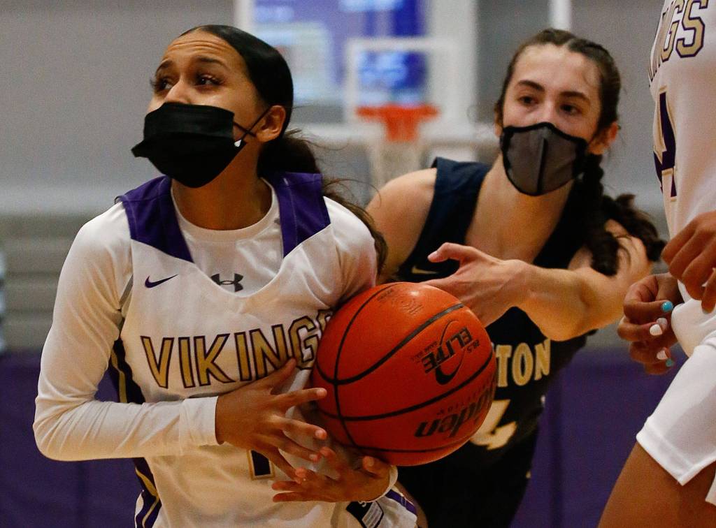 Lake Stevens Perla Ruiz (left) drives with Arlingtons Jenna Villa trailing during a game on Wednesday evening at Lake Stevens High School. Arlington won 80-71. (Kevin Clark / The Herald)