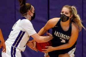 Lake Stevens' Melanie Delestrez (left) and Arlington's Abby Schwark tangle up for a jump ball Wednesday evening at Lake Stevens High School on June 9, 2021. (Kevin Clark / The Herald)