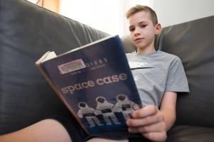 Willem Wolters, 9, is half way through reading "Space Case" by Stuart Gibbs. Wolters was given the title of the nation's highest point earner in the Accelerated Reader program on Thursday, June 17, 2021 in Bothell, Washington. Willem is a fourth grader at Cedar Wood Elementary School in Bothell. The new national record is 2,145 points. That is over 14 million words read and 377 books. (Andy Bronson / The Herald)