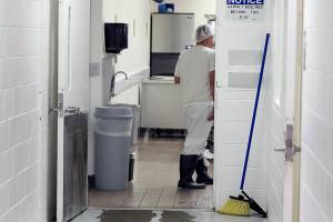 In this photo taken Sept. 10, 2019, a detainee works in a kitchen area at the GEO Group’s immigration jail in Tacoma, Wash., during a media tour. After nearly four years of litigation and pandemic-related delays, a federal jury on Tuesday, June 15, 2021, began deliberating whether the GEO Group must pay minimum wage to detainees who perform cooking, cleaning and other tasks at the facility – instead of the $1 per day they typically receive. (AP Photo/Ted S. Warren)