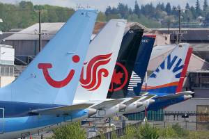 Boeing 737 Max airplanes, including one belonging to TUI Group, left, sit parked at a storage lot, Monday, April 26, 2021, near Boeing Field in Seattle.  Lawmakers, on Tuesday, May 18,  are asking Boeing and the Federal Aviation Administration for records detailing production problems with two of the company's most popular airliners. The lawmakers are focusing on the Boeing 737 Max and a larger plane, the 787, which Boeing calls the Dreamliner.  (AP Photo/Ted S. Warren)