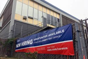 The Everett Post Office is shown with a "now hiring" sign in 2019. (Sue MIsao / Herald file)