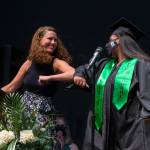Hayley Simkins bumps elbows after introducing Jessica Clark, right, during Sequoia Highs graduation ceremony on Thursday, June 17, 2021 in Everett, Washington. (Andy Bronson / The Herald)