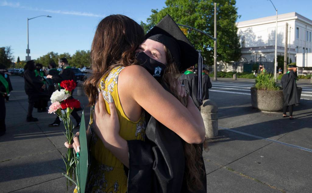 Jamie Burton hugs graduate Mackenzie Kockritz after Sequoia High helds its graduation ceremony Thursday in Everett. (Andy Bronson / The Herald)