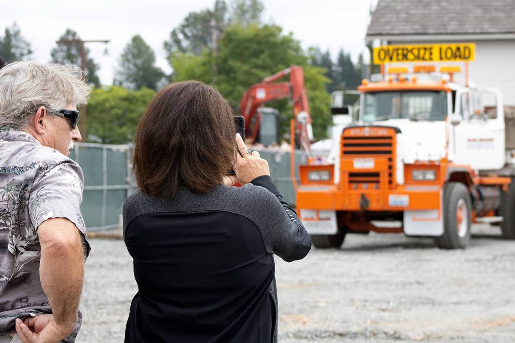 Lake Stevens residents Robert Loss (left) and Carol Ward watch as the Grimm House is towed to its new home. (Isabella Breda / The Herald)