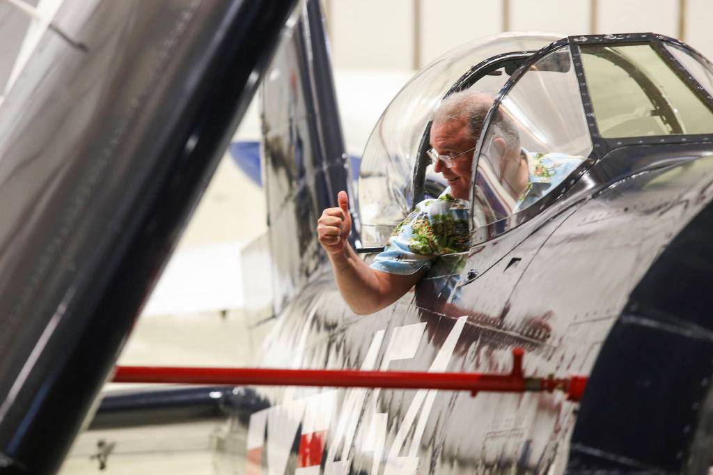 John Stefanov gives a thumbs-up as he sits in the cockpit of the Goodyear F2G-1 Super Corsair on Wednesday in Everett. (Andy Bronson / The Herald)