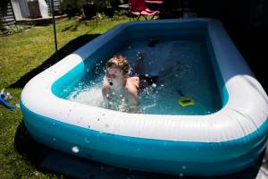 Adrian, 7, jumps into his pool in the yard of his home while enjoying the warm weather on Thursday, June 24, 2021. (Olivia Vanni / The Herald)