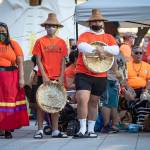 People listen during a ceremony and vigil for the 215 children whose remains were found buried at the former Kamloops Indian Residential School, in Vancouver, British Columbia, on National Indigenous Peoples Day, Monday, June 21, 2021. (Darryl Dyck/The Canadian Press via AP)
