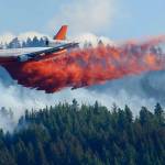 FILE - In this Aug. 21, 2015 file photo, a tanker airplane drops fire retardant on a wildfire burning near Twisp, Wash. Three firefighters were killed battling the blaze. The story was a top Washington state news item in 2015. Public Lands Commissioner Hilary Franz has proposed a plan to strengthen the ways that Washington can prevent and respond to wildfires. Franz released the 10-year plan last week as part of her $55 million budget request to the Legislature to improve the state's firefighting abilities (AP Photo/Ted S. Warren, File)
