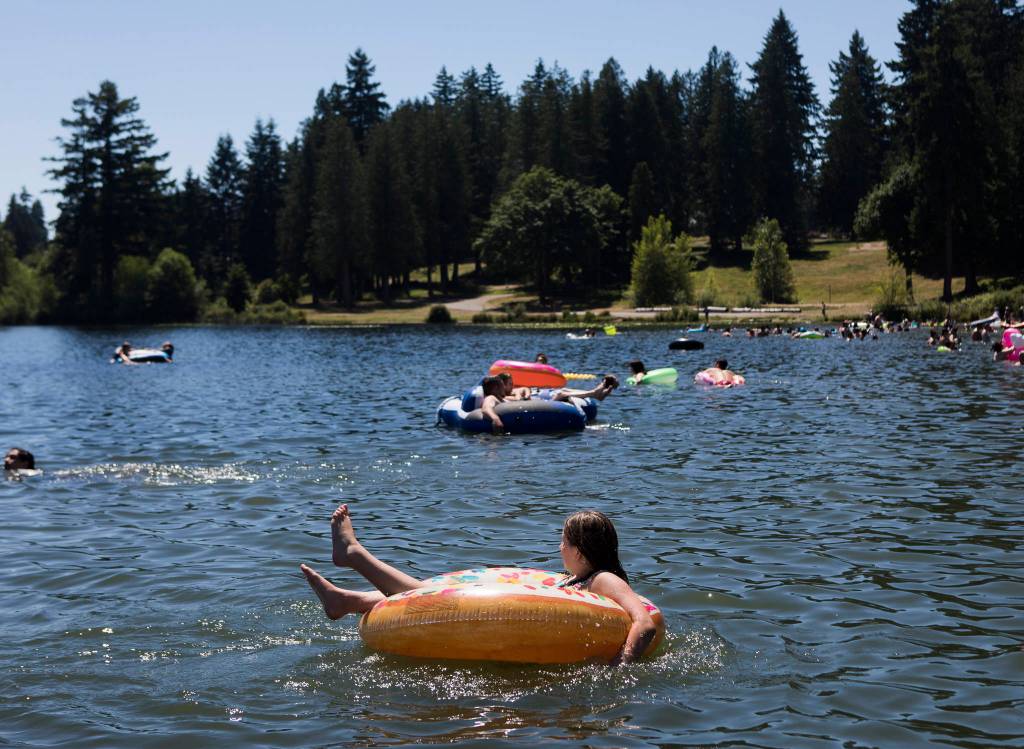 Ariana Blibd, 10, sits in a donut inner tube Saturday on Silver Lake at Thornton A. Sullivan Park in Everett. (Olivia Vanni / The Herald)