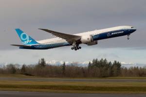 With the Olympic mountains in the background, Boeing's 777x  lifts off from Paine Field on its first flight, to Boeing Field in Seattle, on Saturday, Jan. 25, 2020 in Everett, Wash. (Andy Bronson / The Herald)