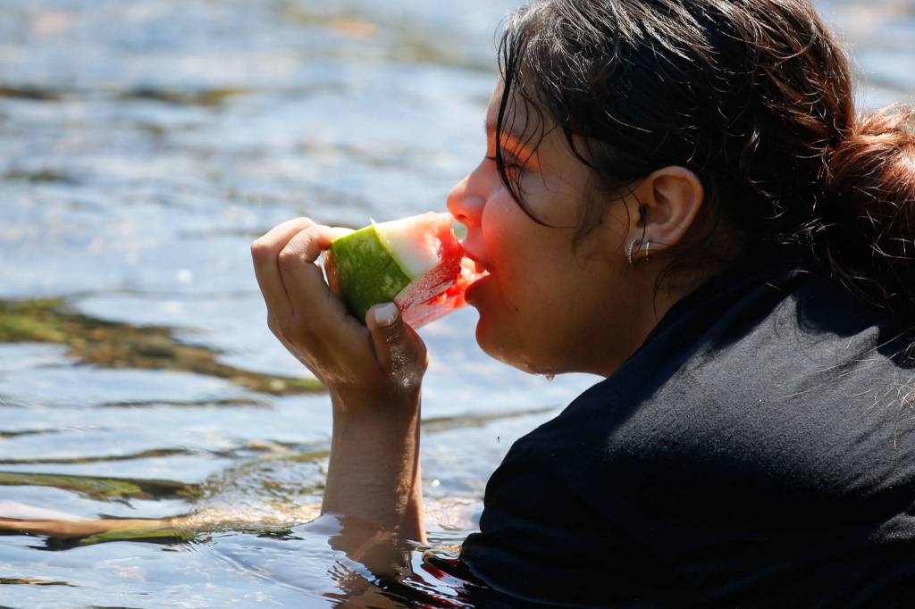 Cooling off in the Pilchuck River in Snohomish Monday. (Kevin Clark / The Herald)