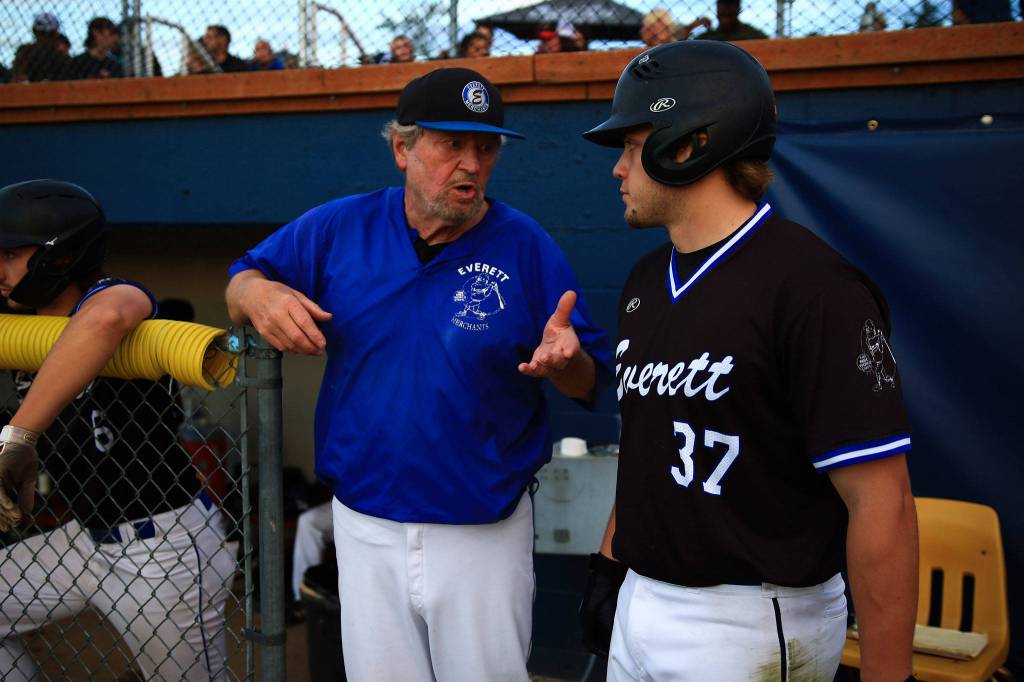 Merchants coach Harold Pyatte (left) and Jaxsen Sweum chat in the dugout during the 116th Midnight Sun Game against the Goldpanners on June 21 in Fairbanks, Alaska. (Photo by Justin Prax)