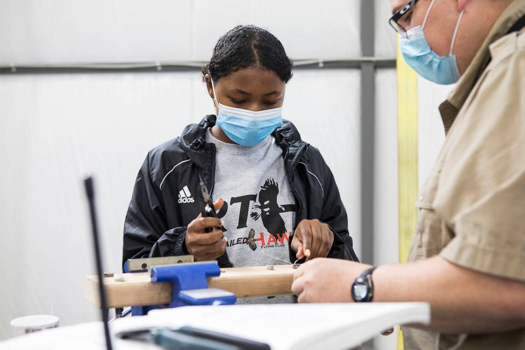 Erin Howard, 15, learns how to make a piece of safety wiring during a Red-Tailed Hawks Flying Club program at Arlington Municipal Airport. (Olivia Vanni / The Herald)