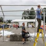 Jeff Irtter (left) and Tom Glasenapp work it dismantle a tent of the covid vaccination station Wednesday morning at the Evergreen State Fairgrounds in Monroe on June 30th, 2021. (Kevin Clark / The Herald)