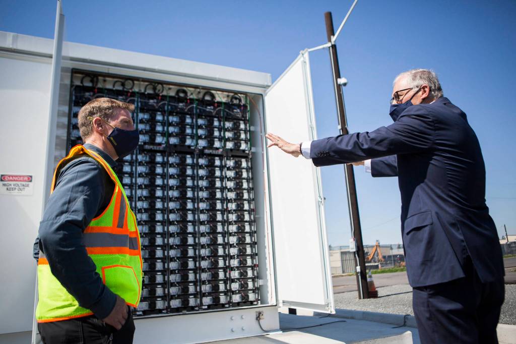Gov. Jay Inslee (right) speaks to principal engineer Scott Gibson about the microgrid batteries. (Olivia Vanni / The Herald)