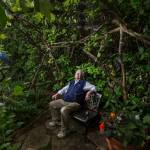 Bill Taylor sits in an area called Hobbit House in his garden Tuesday in Edmonds. The Taylors home is a stop on the Edmonds in Bloom garden tour to be held on July 18. (Andy Bronson / The Herald)
